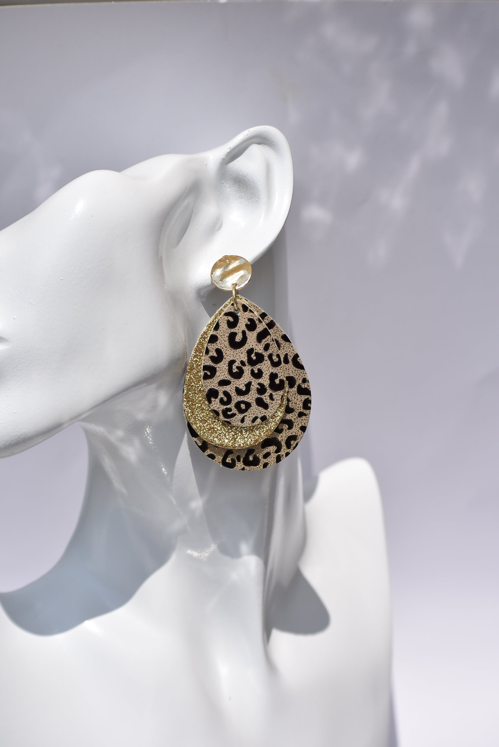 ﻿These gold stunners are sure to get attention.  Gold posts and gold glitter and leopard print teardrops bring these earrings to life.  You will be roaring in these.  