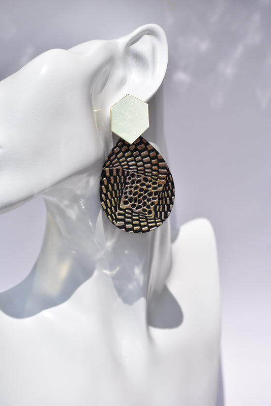 ﻿Looking for something different? These black/gold faux leather teardrops are definitely that piece.  This unique pattern with a bold gold post are an eye catcher on the ear.  Don't miss out on this one-of-a-kind piece.  