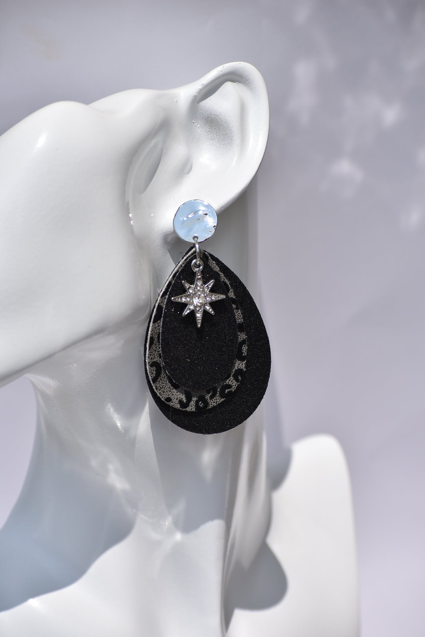 Black glitter teardrops hold a center leopard print in black and gray.  A pretty crystal star charm hangs from the top of these silver post earrings.  