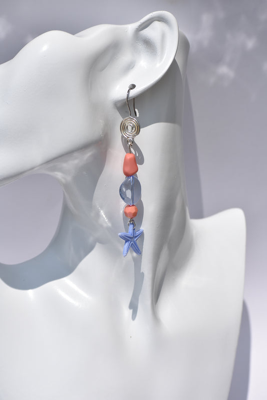 The Key West Collection 10 offers fashionable statement earrings that are perfect for summer. These earrings feature a combination of gorgeous orange and blue mixed beads, a blue starfish charm at the bottom, and silver hooks. The extra length is optimal for those who love to showcase longer earrings.