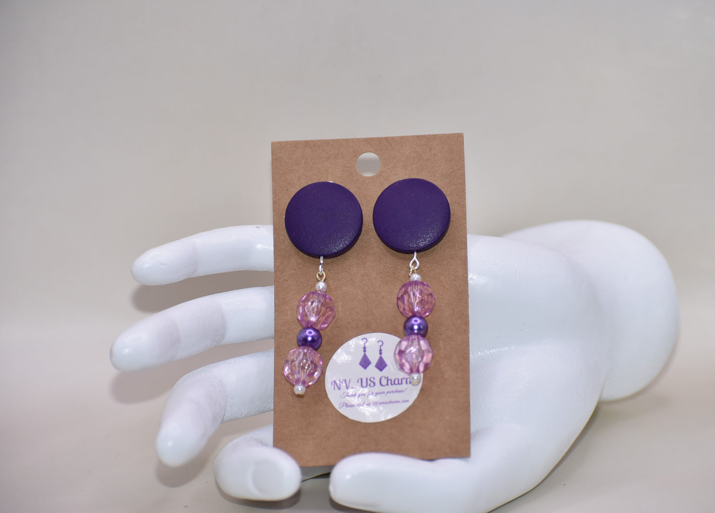 "Looking for something unique and fun? The Purple Collection is a one-of-a-kind piece featuring dark purple posts adorned with pretty purple beads and pearls. Stand out and add a playful touch to your accessory game with this quirky addition!"