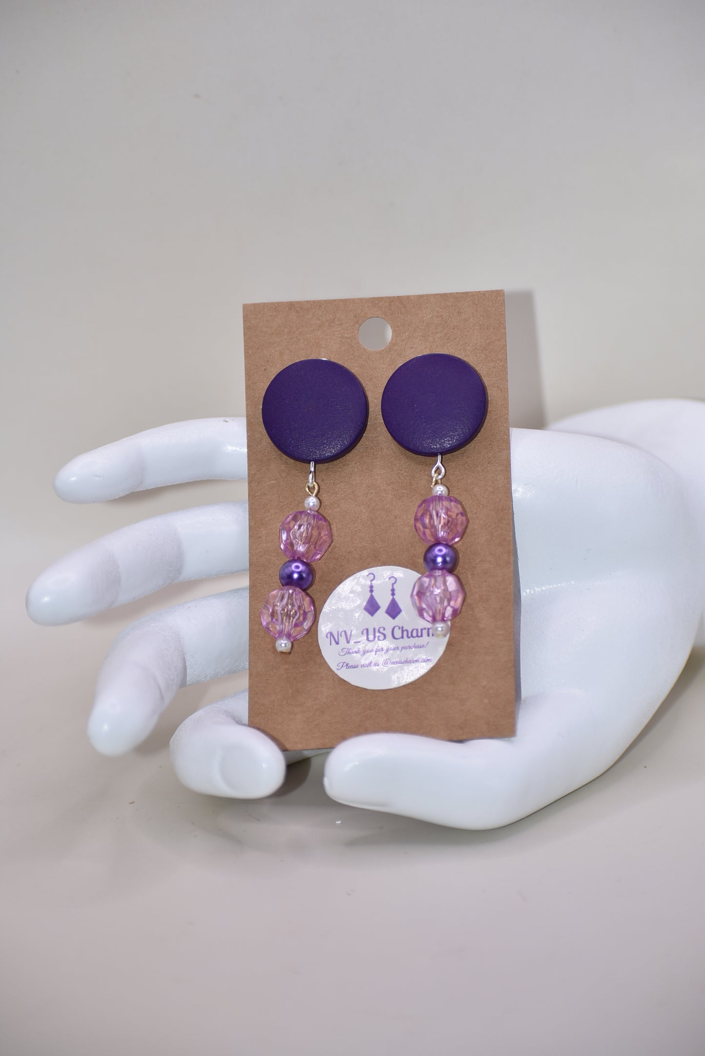 "Looking for something unique and fun? The Purple Collection is a one-of-a-kind piece featuring dark purple posts adorned with pretty purple beads and pearls. Stand out and add a playful touch to your accessory game with this quirky addition!"