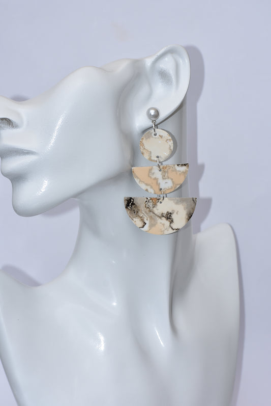 Experience the beauty of our White Collection 4 earrings. These hypoallergenic posts feature a unique three-tiered design in a combination of whites, creams, and gray. The perfect addition to any outfit, these lightweight and comfortable earrings hang about 2 1/2 inches from the ear. Made with vinyl faux leather material for a touch of luxury.