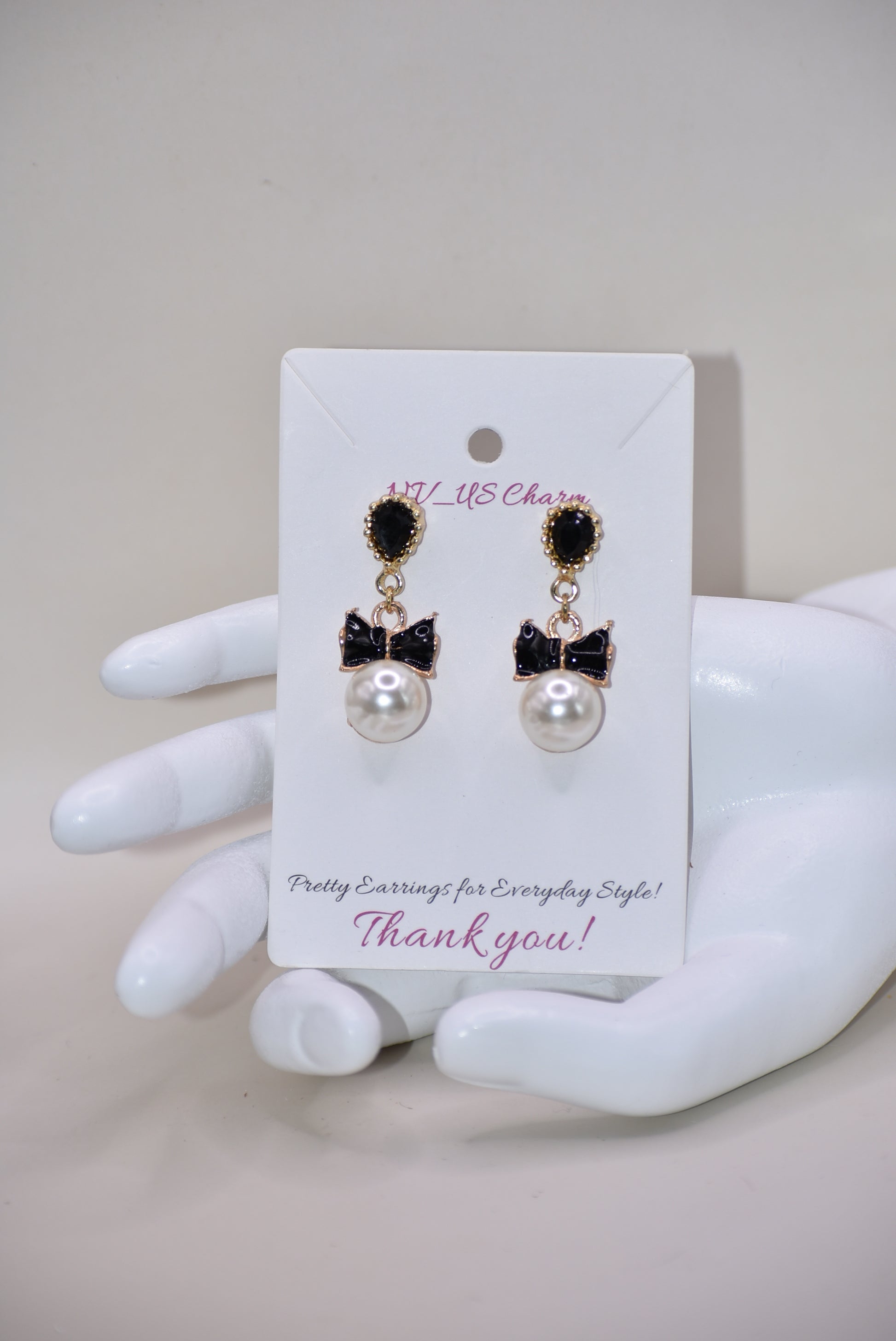 Introducing our Wedding Collection, the perfect choice for those looking for unique and stylish earrings. Our black and gold pear shaped posts feature a stunning large pearl and black tie charm, adding a touch of elegance to any outfit. Crafted with comfort and hypoallergenic materials, these earrings are perfect for sensitive ears.