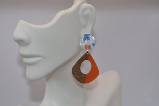 Get ready to up your accessory game with the Orange Collection! These resin and wood hoop earrings are both stylish and comfortable, making them the perfect addition to any outfit. The round resin post features a playful periwinkle and orange confetti design and is hypoallergenic, ensuring comfort for even the most sensitive ears. Don't miss out on these adorable earrings!