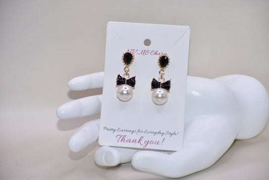 Introducing our Wedding Collection, the perfect choice for those looking for unique and stylish earrings. Our black and gold pear shaped posts feature a stunning large pearl and black tie charm, adding a touch of elegance to any outfit. Crafted with comfort and hypoallergenic materials, these earrings are perfect for sensitive ears.