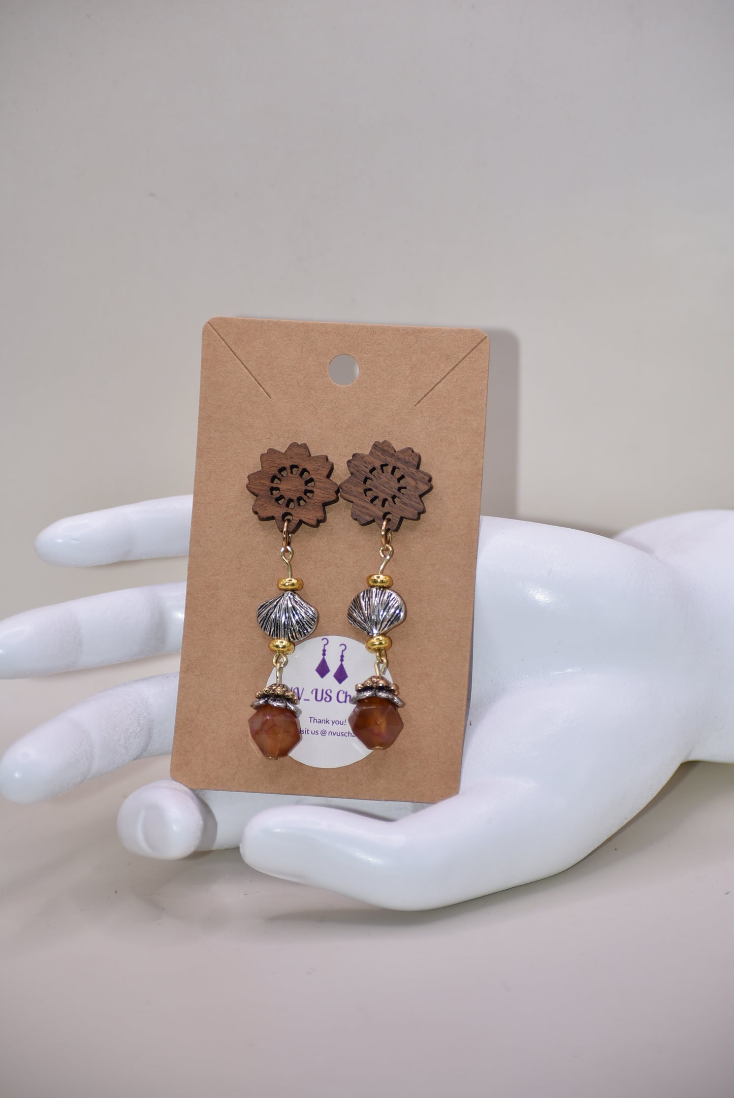 Get ready to make a statement with our Brown Collection! Featuring a one-of-a-kind piece with unique wood flowered post earrings and hanging seashell charms adorned with a pretty stone, this collection offers a great mix of brown, silver, and gold tones. Stand out with a touch of elegance and playfulness.