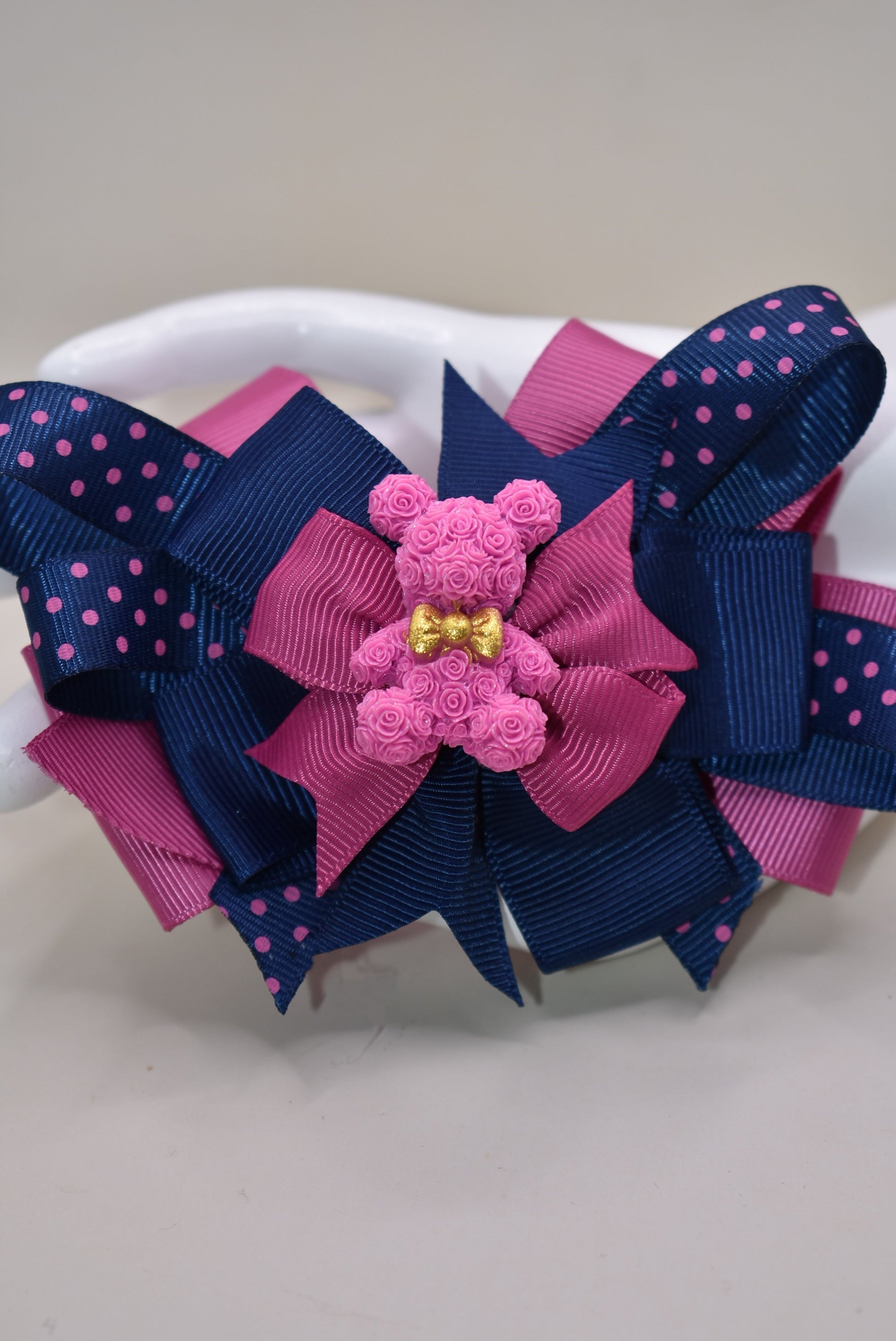 Calling all Teddy Bear lovers! 🧸 This adorable cutie from Nana's Collection 101 shines in a perfect mix of pink and navy blue. Made from high-quality grosgrain fabric, it’s soft and charming—guaranteed to steal your heart! 💖 Plus, the wrapped alligator clip on the back ensures comfy, all-day wear wherever you go. Clip it, love it, and let the fun begin! 🎀🐻