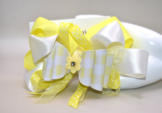 Add a splash of sunshine to your look with this playful hair clip from Nana's Collection 166. Featuring a cheerful mix of yellow and white ribbons accented with charming polka dots, it’s topped with a cute yellow flower and sparkling crystal for a touch of sparkle. The wrapped alligator clip ensures a secure hold, making it perfect for brightening any hairstyle with a fun, whimsical flair.