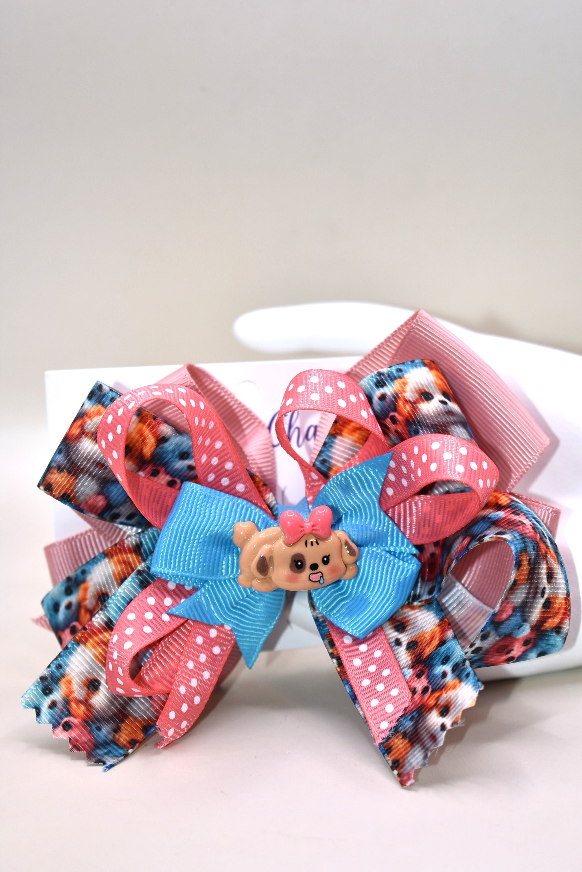Add a splash of fun with this adorable dog charm from Nana's Collection! Featuring layers of a cute pup and a cheerful polka dot ribbon, it clips on easily with a wrapped alligator clip—perfect for quick, playful style. 🐶🎀 Clip it on and let the smiles begin!