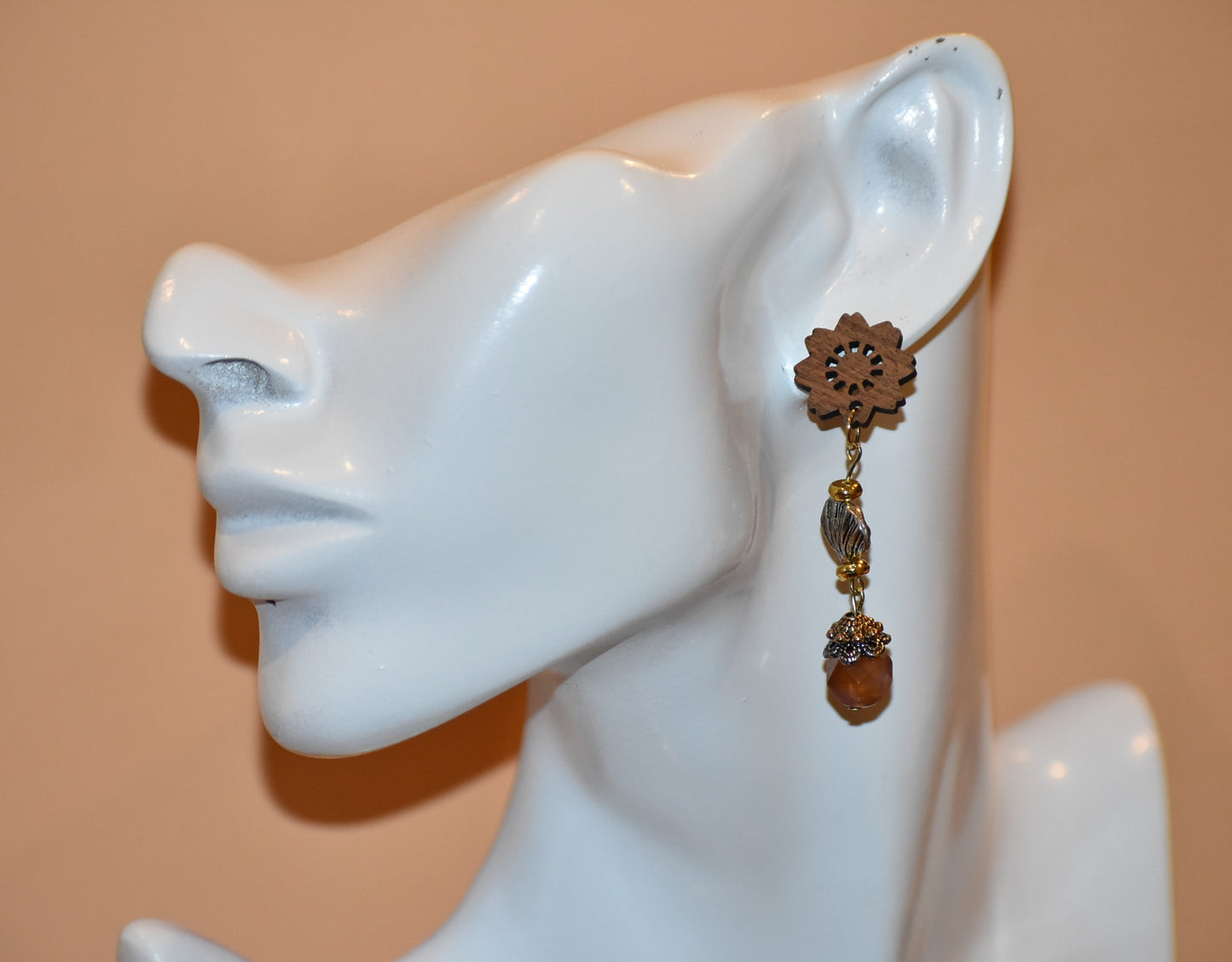 Get ready to make a statement with our Brown Collection! Featuring a one-of-a-kind piece with unique wood flowered post earrings and hanging seashell charms adorned with a pretty stone, this collection offers a great mix of brown, silver, and gold tones. Stand out with a touch of elegance and playfulness.