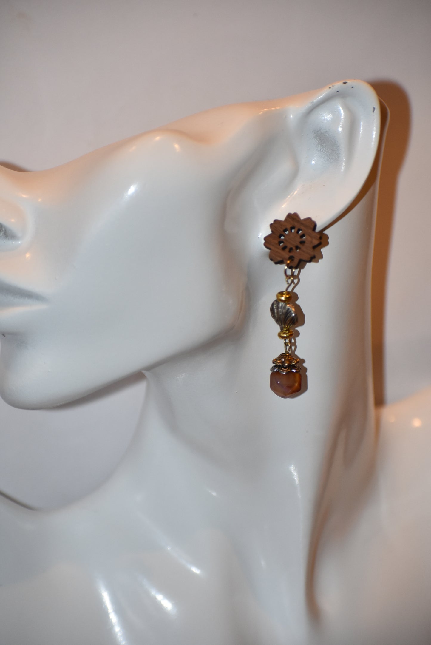 Get ready to make a statement with our Brown Collection! Featuring a one-of-a-kind piece with unique wood flowered post earrings and hanging seashell charms adorned with a pretty stone, this collection offers a great mix of brown, silver, and gold tones. Stand out with a touch of elegance and playfulness.