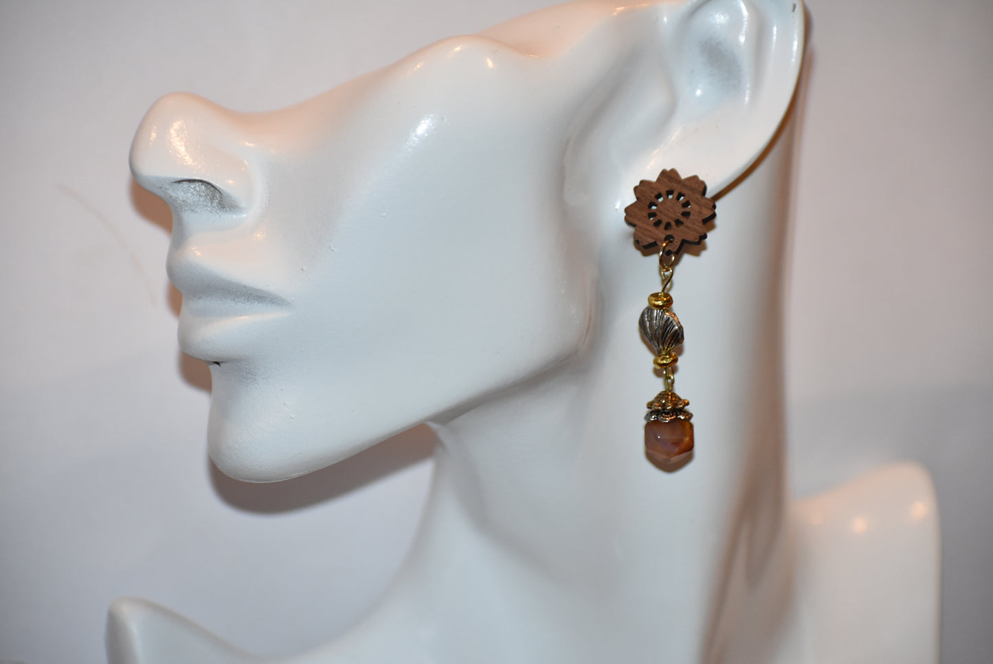 Get ready to make a statement with our Brown Collection! Featuring a one-of-a-kind piece with unique wood flowered post earrings and hanging seashell charms adorned with a pretty stone, this collection offers a great mix of brown, silver, and gold tones. Stand out with a touch of elegance and playfulness.