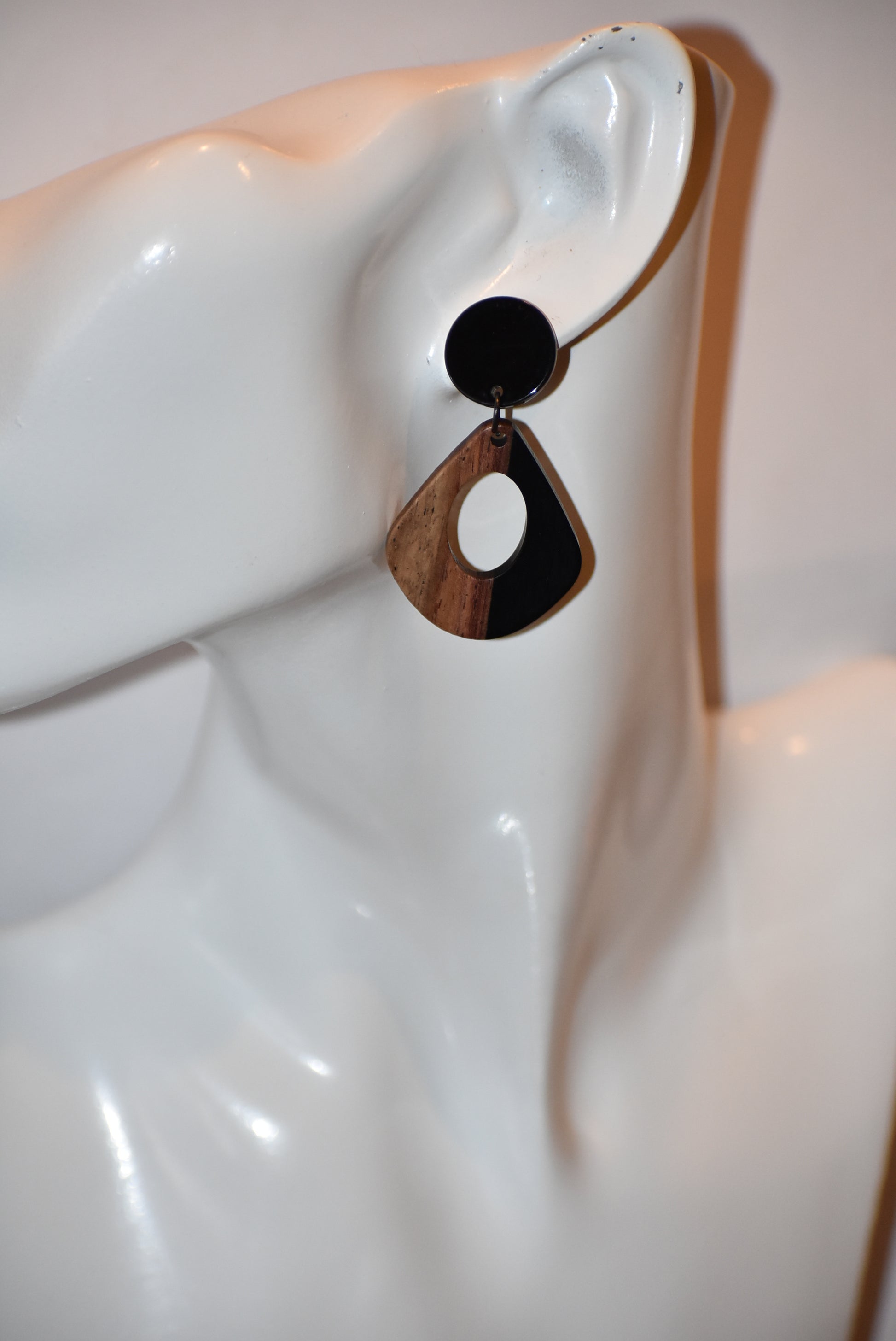 Elevate your wardrobe with our Black Collection! These stunning oval earrings, held by black round posts, will perfectly complement any outfit. Whether dressing up or down, these black resin and wood beauties are sure to make a statement. A must-have for any fashionista!