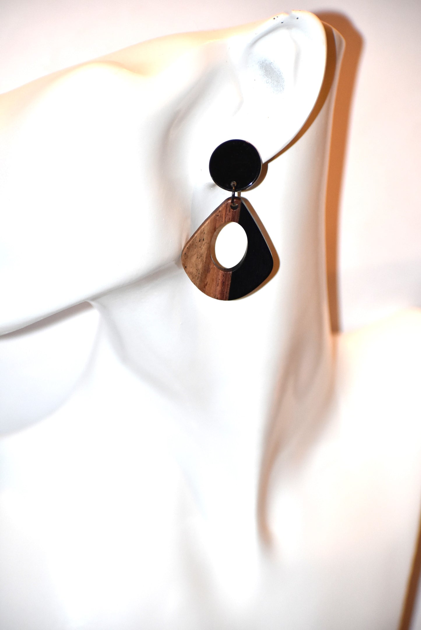 Elevate your wardrobe with our Black Collection! These stunning oval earrings, held by black round posts, will perfectly complement any outfit. Whether dressing up or down, these black resin and wood beauties are sure to make a statement. A must-have for any fashionista!