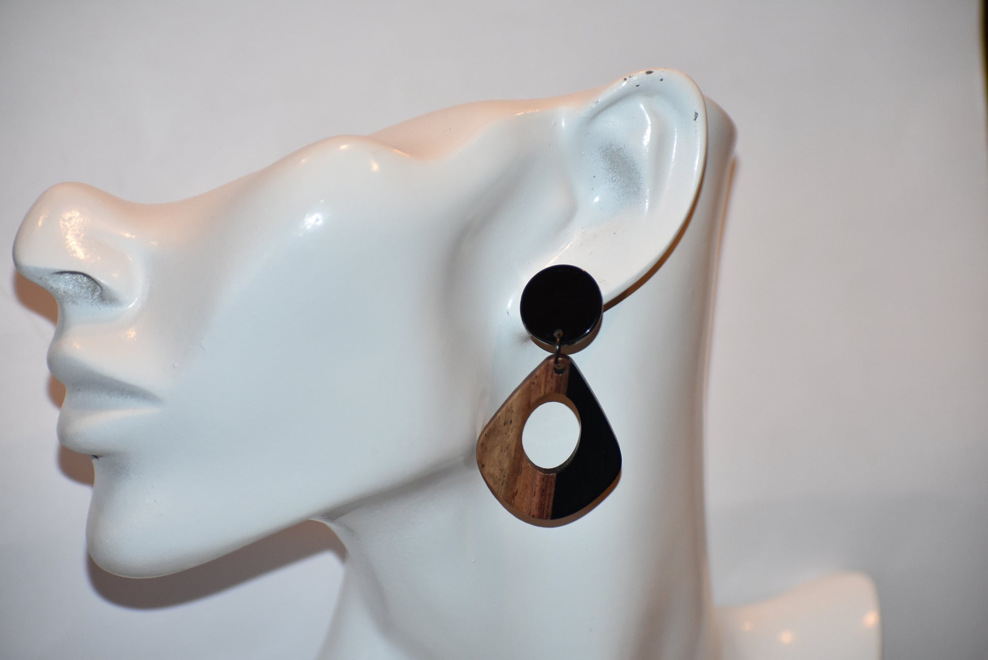 Elevate your wardrobe with our Black Collection! These stunning oval earrings, held by black round posts, will perfectly complement any outfit. Whether dressing up or down, these black resin and wood beauties are sure to make a statement. A must-have for any fashionista!