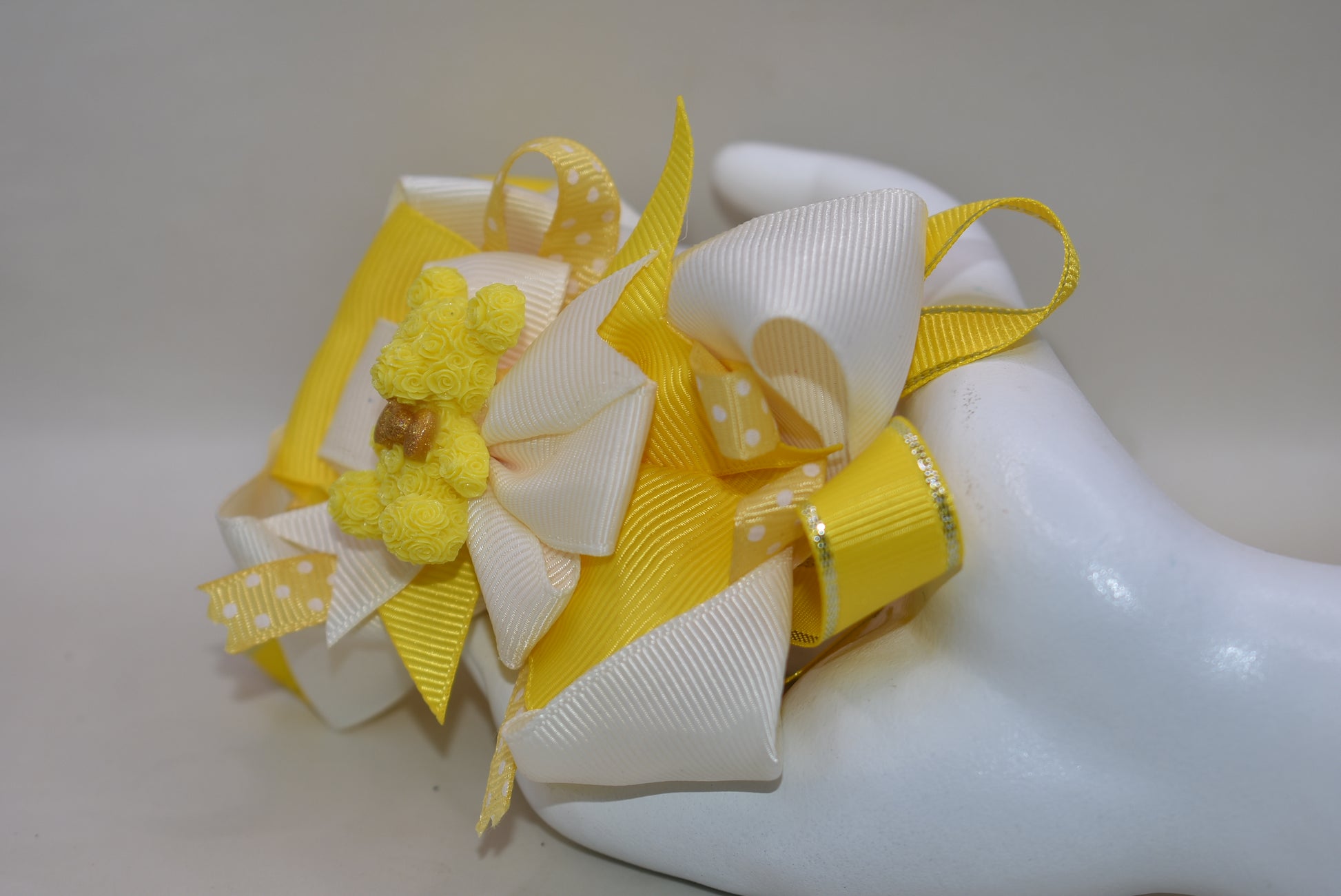 Brighten your day with Nana's Collection 141! 🌟 This adorable yellow bear perches atop layers of sunny yellow and creamy ribbons, making it the perfect playful accessory. 🐻💛 The alligator clip ensures it stays put, adding a cheerful touch wherever you go! 