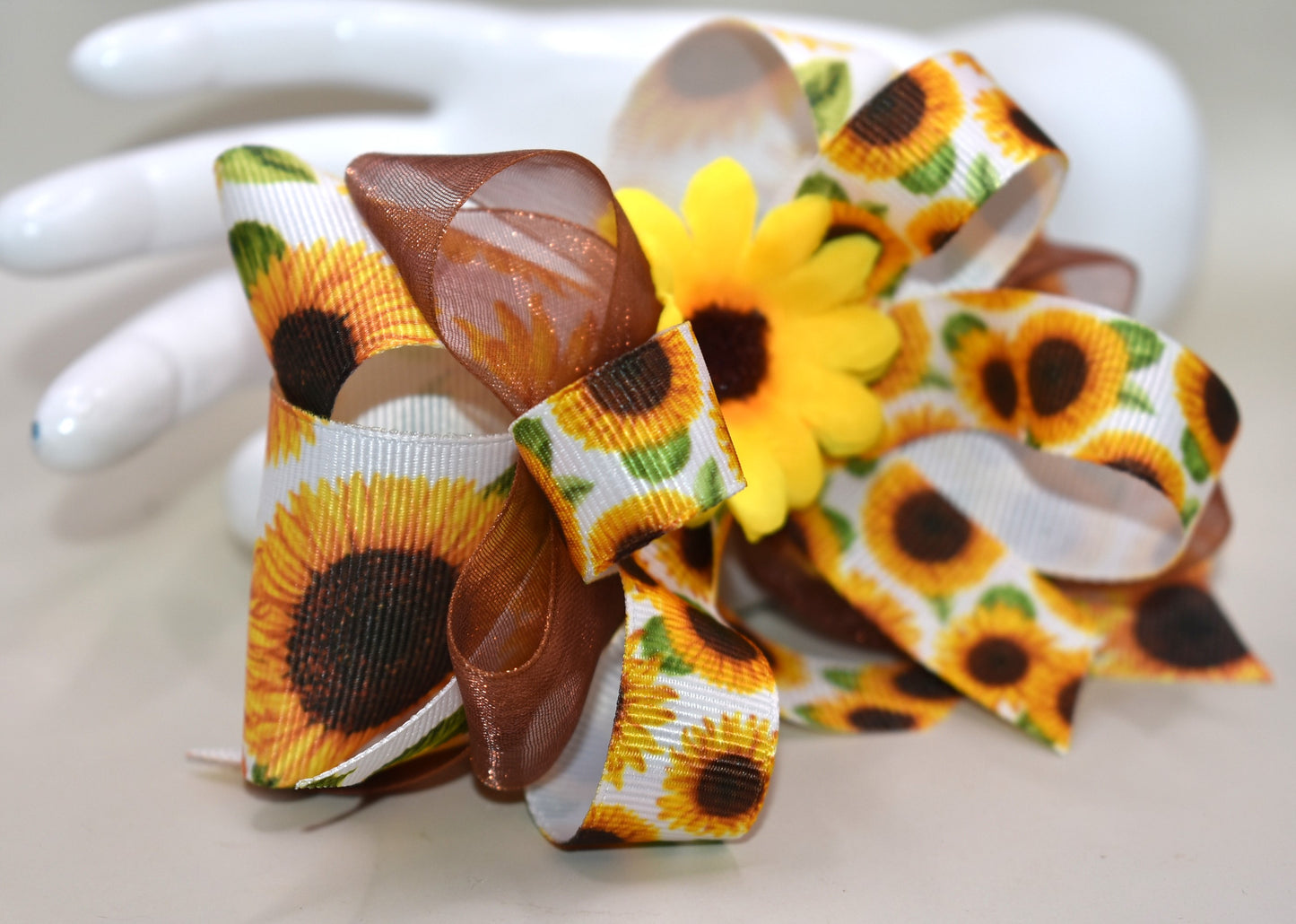 Brighten any day with this playful sunflower bow! 🌻 Layers of cheerful sunflower ribbons stacked just right, topped with a vibrant sunflower bloom for that perfect pop. Easy to wear with a handy alligator clip on the back—ready to add sunshine to your style! ☀️😊