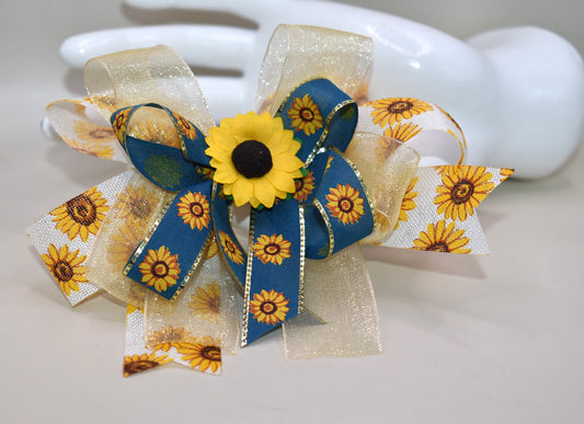 Brighten up your look with Nana's Collection 173! This playful sunflower bow features layers of cheerful sunflowers topped with a pretty floral accent, making it just perfect for fall fun. Securely attached with a wrapped alligator clip, it’s easy to wear and adds a stylish touch to any outfit. 🍂🌻✨ Let your style bloom this season!