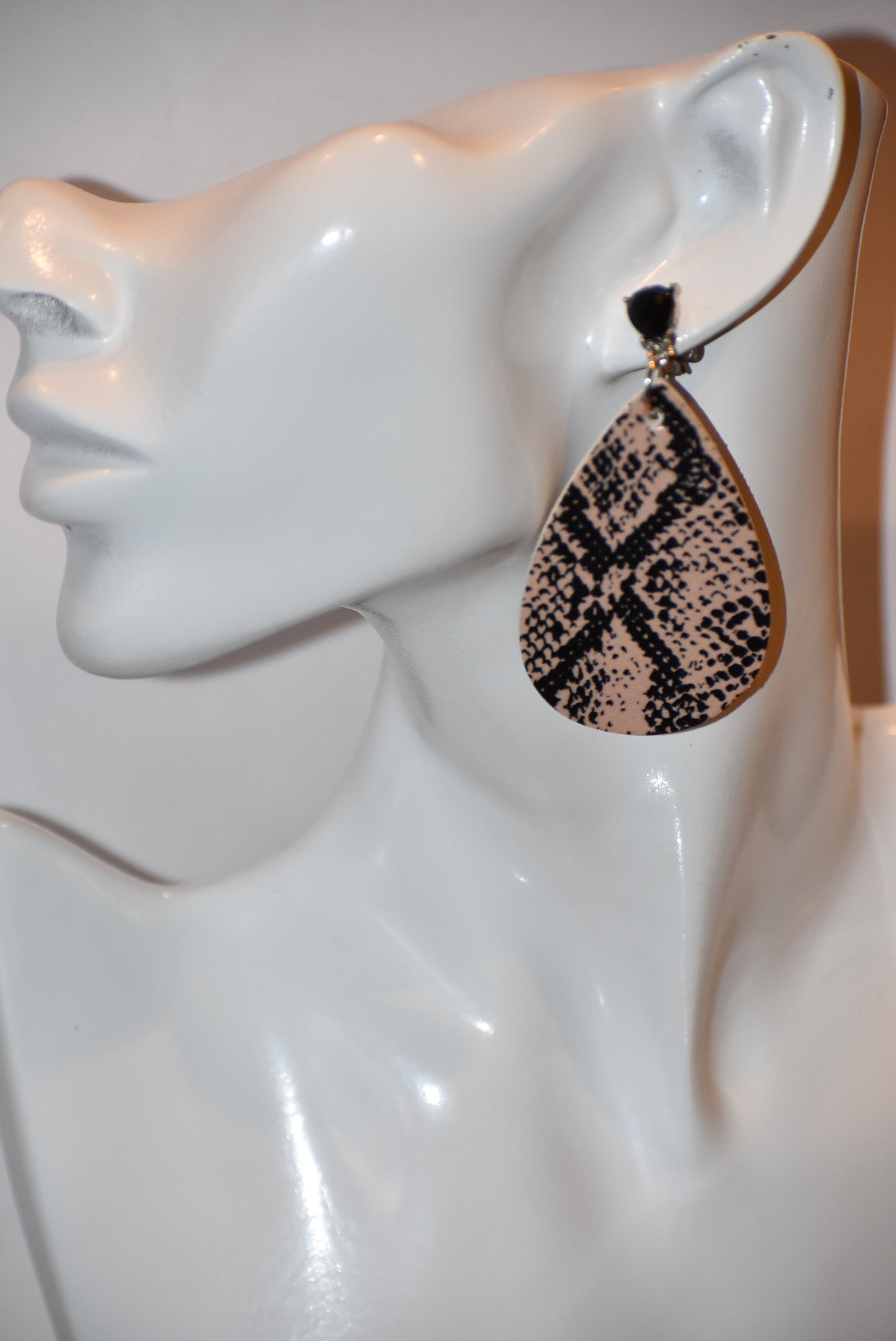 "Unleash your wild side with our Safari Collection! These faux leather earrings feature a stylish snake skin design and comfortable silver plated posts for durability. Add some fun accents to your outfit with black gem detailing. 🐍💎✨"