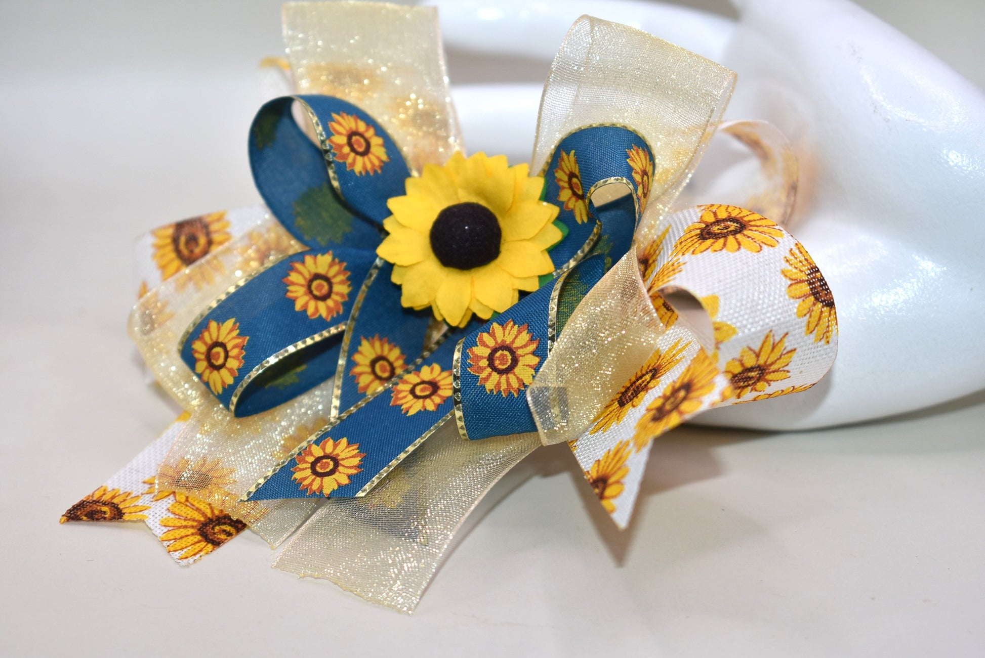 Brighten up your look with Nana's Collection 173! This playful sunflower bow features layers of cheerful sunflowers topped with a pretty floral accent, making it just perfect for fall fun. Securely attached with a wrapped alligator clip, it’s easy to wear and adds a stylish touch to any outfit. 🍂🌻✨ Let your style bloom this season!