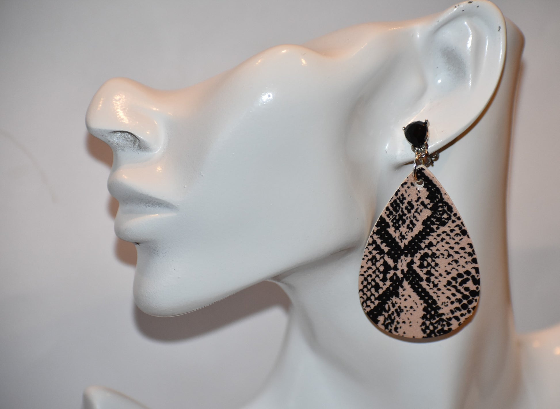 "Unleash your wild side with our Safari Collection! These faux leather earrings feature a stylish snake skin design and comfortable silver plated posts for durability. Add some fun accents to your outfit with black gem detailing. 🐍💎✨"