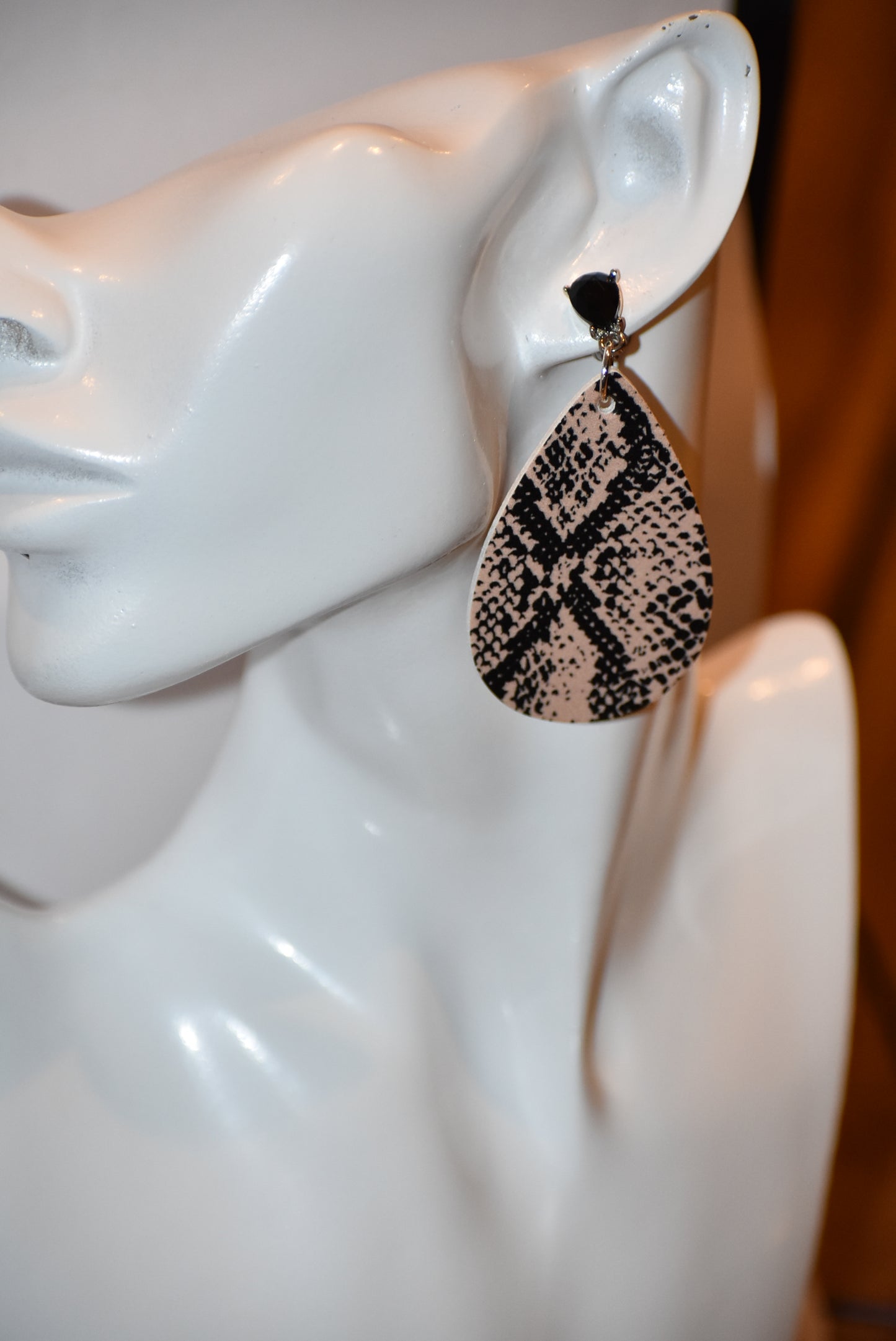 "Unleash your wild side with our Safari Collection! These faux leather earrings feature a stylish snake skin design and comfortable silver plated posts for durability. Add some fun accents to your outfit with black gem detailing. 🐍💎✨"