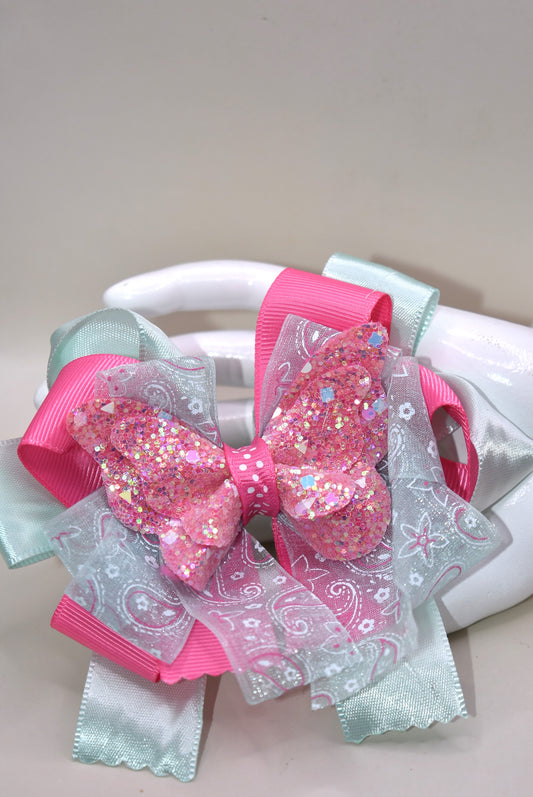 Add a touch of magic with this glittery butterfly perched atop a delicate mint green and pink ribbon. The comfy alligator clip keeps it secure, making it perfect for your little one to wear all day. Pretty, elegant, and absolutely adorable—watch her fall in love and never want to take it off! 🦋💚🎀