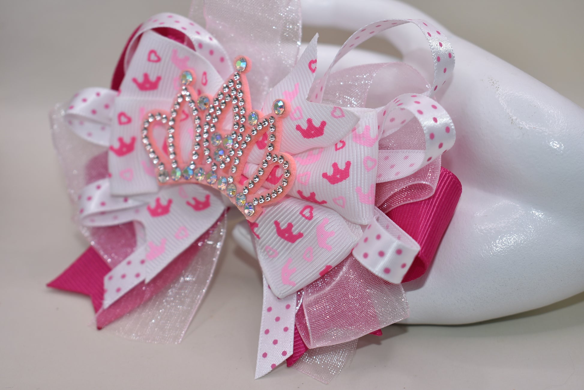 Add a touch of magic with this perfect pink princess bow! 🎀 Layers of ribbon featuring a charming princess motif come together topped with a sparkling pink glitter crown 👑. This one-of-a-kind bow clips securely with an alligator wrapped clip, making it a delightful accessory for any little princess. ✨