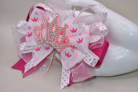 Add a touch of magic with this perfect pink princess bow! 🎀 Layers of ribbon featuring a charming princess motif come together topped with a sparkling pink glitter crown 👑. This one-of-a-kind bow clips securely with an alligator wrapped clip, making it a delightful accessory for any little princess. ✨