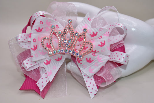 Add a touch of magic with this perfect pink princess bow! 🎀 Layers of ribbon featuring a charming princess motif come together topped with a sparkling pink glitter crown 👑. This one-of-a-kind bow clips securely with an alligator wrapped clip, making it a delightful accessory for any little princess. ✨