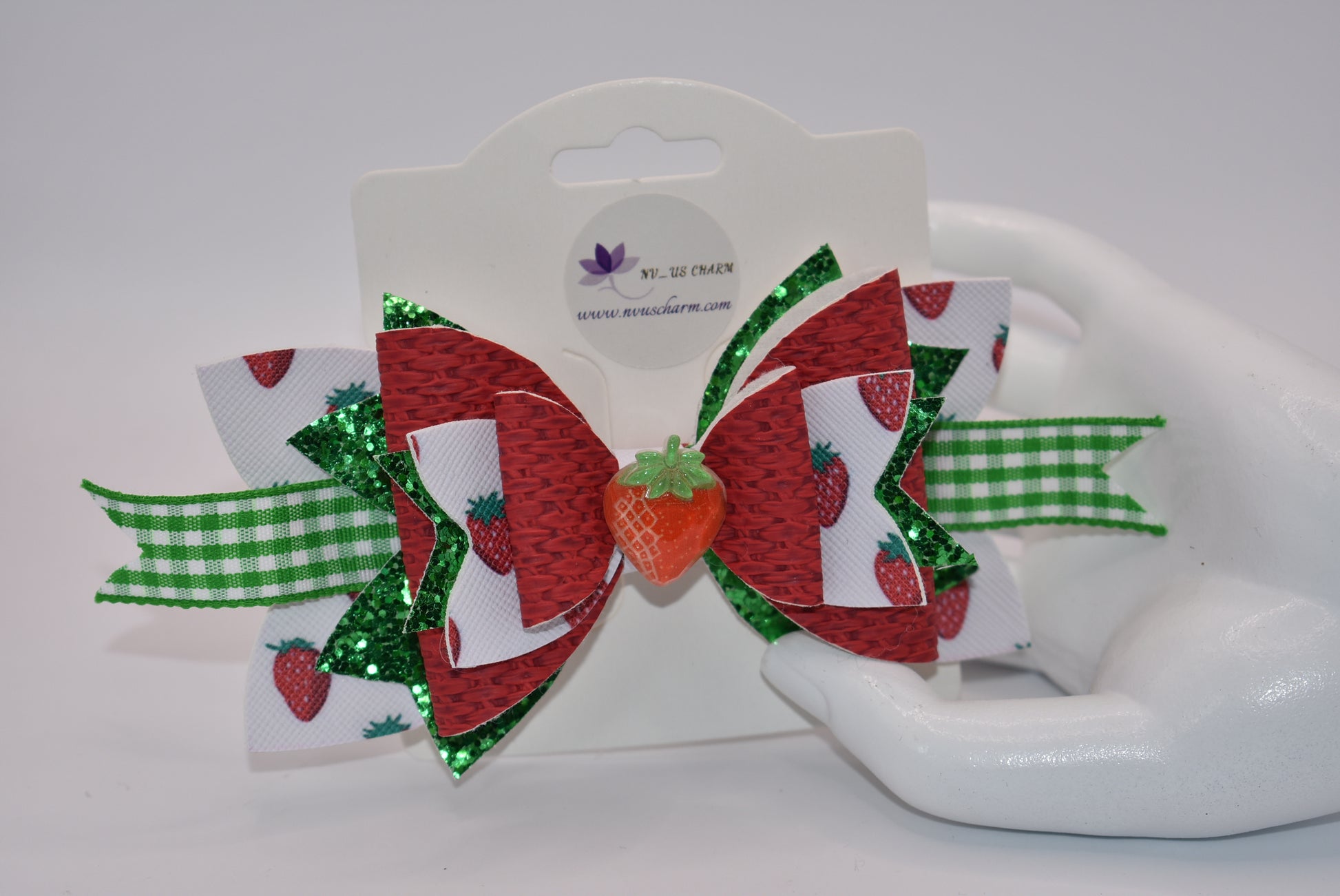 Indulge in the juicy sweetness of Nana's Collection hair clip! Made with strawberry design faux leather and a cute green and white checkered ribbon, this clip is perfect for summer with a charming strawberry charm. Plus, the alligator clip makes it easy to put in and take out of your little one's hair.