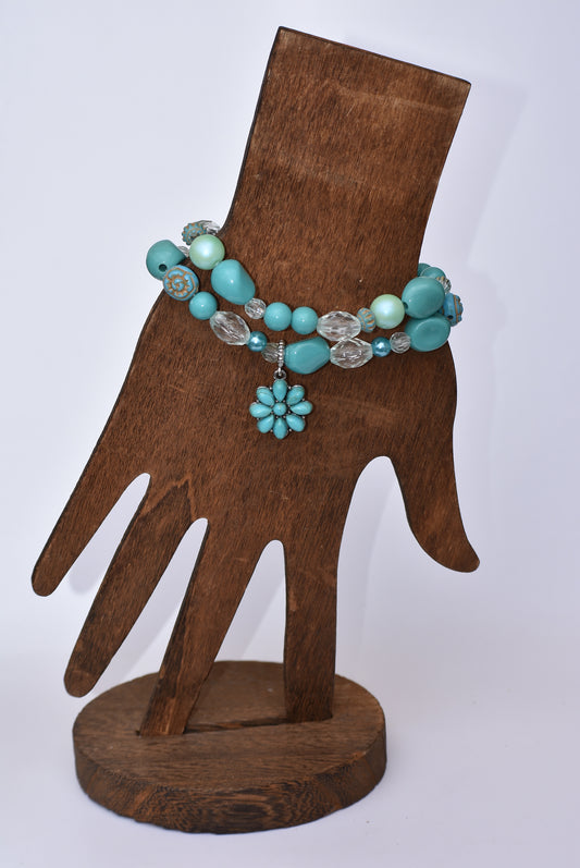 This Western Collection two-piece bracelet set is one-of-a-kind, featuring aqua beading of different shapes accented with white crystal beads and a lovely aqua flower charm. Perfect for any occasion, this set makes a statement without being too flashy.