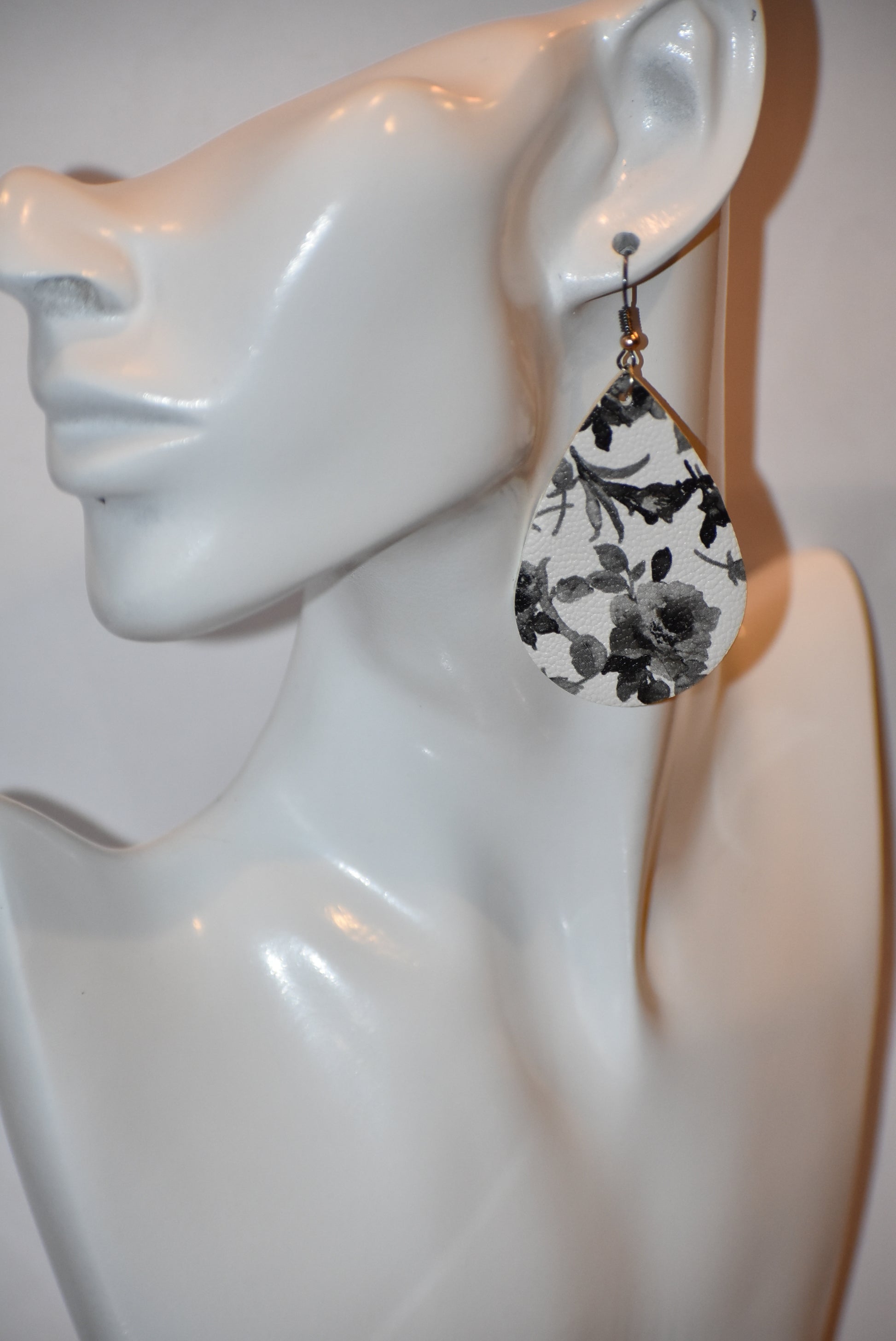 Add a touch of playfulness to any outfit with our Key West Collection earrings! These unique faux leather teardrop earrings feature a pretty black and white flower design and a quirky black hook with a gold ball. Comfortable yet stylish, they're perfect for dressing up or down. 😉