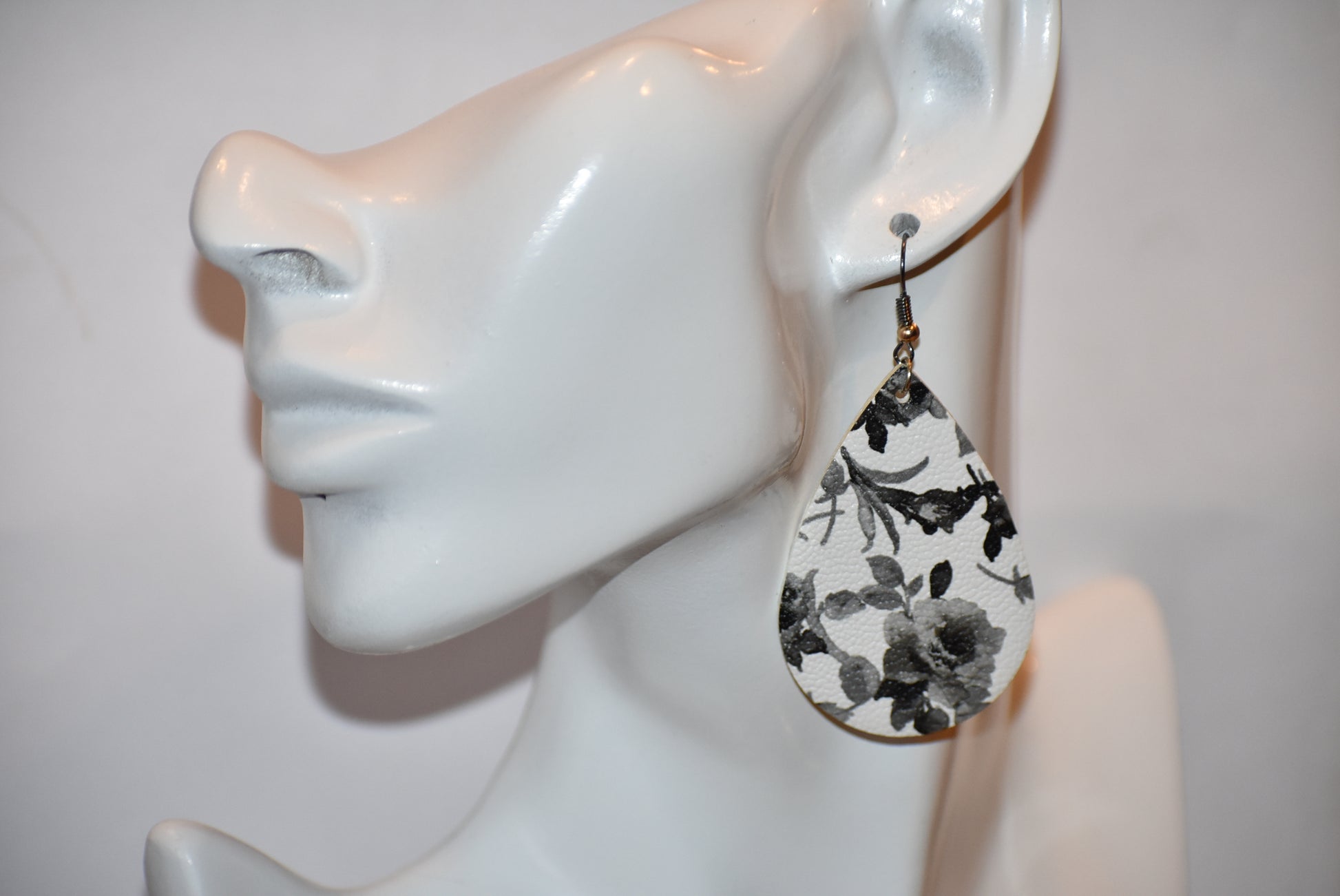 Add a touch of playfulness to any outfit with our Key West Collection earrings! These unique faux leather teardrop earrings feature a pretty black and white flower design and a quirky black hook with a gold ball. Comfortable yet stylish, they're perfect for dressing up or down. 😉