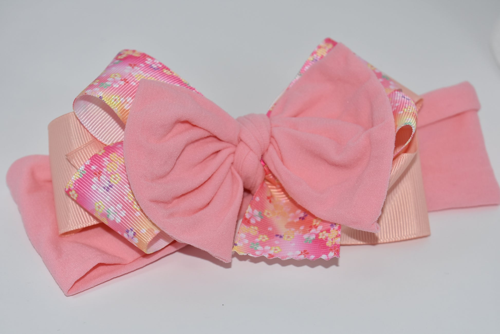Wrap your hair in sweetness with this charming headband! 🎀 Featuring delicate layers of ribbon and soft nylon, it's designed for all-day comfort without the fuss. The pretty pink hue and cheerful floral pattern add a fun, feminine touch to any outfit. 🌸 Whether you're heading to brunch or running errands, this wrapped beauty keeps your style on point while keeping strands in place. Perfect for anyone who loves a pop of color and playful elegance! ✨