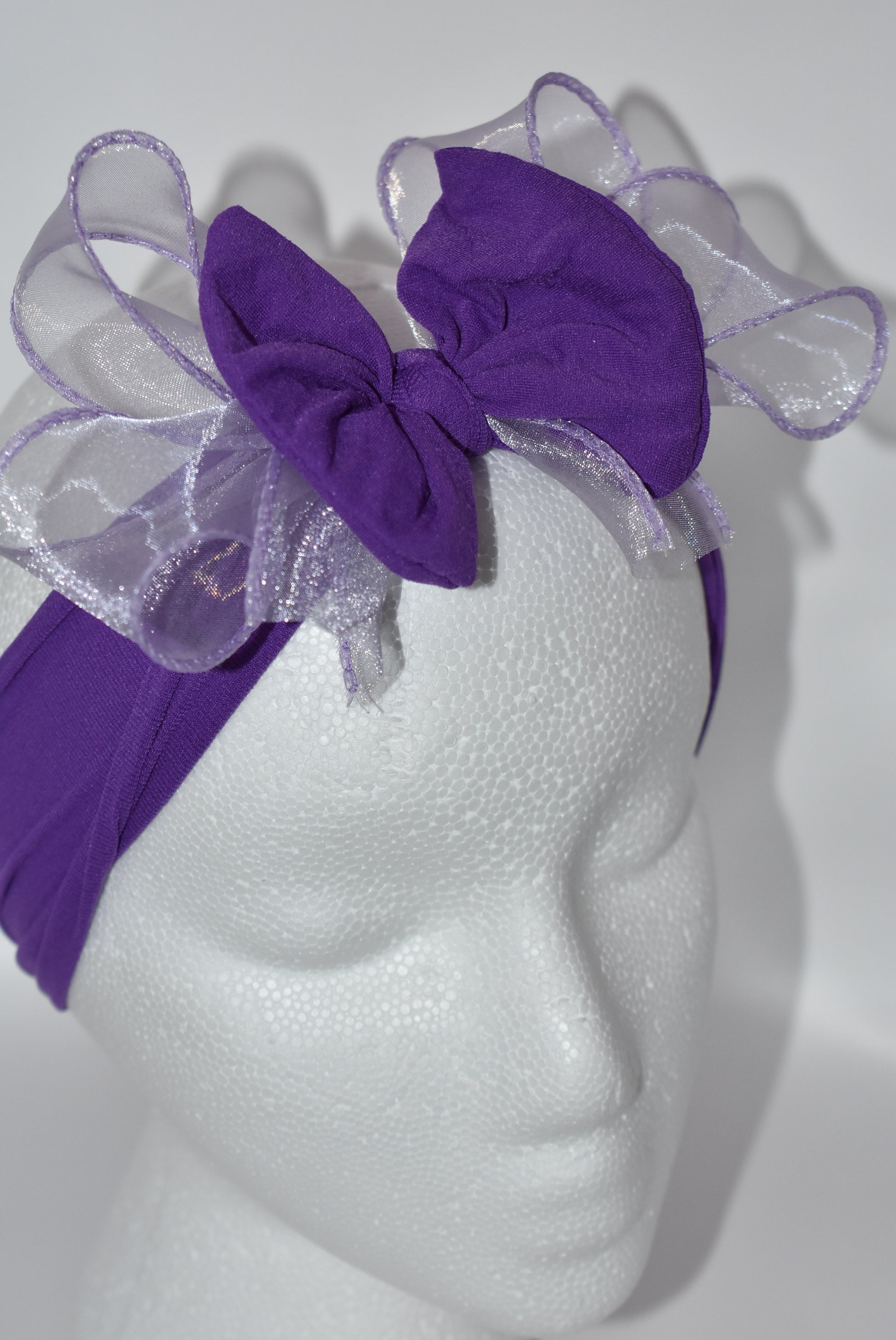Add a vibrant pop of purple with this wide, soft headband from the Wrapped Headband Collection! 🌸 Featuring a delicate organza bow right in the center, it brings extra charm and love 💜 Perfect for all ages, it's the playful accessory you need to brighten any outfit! ✨