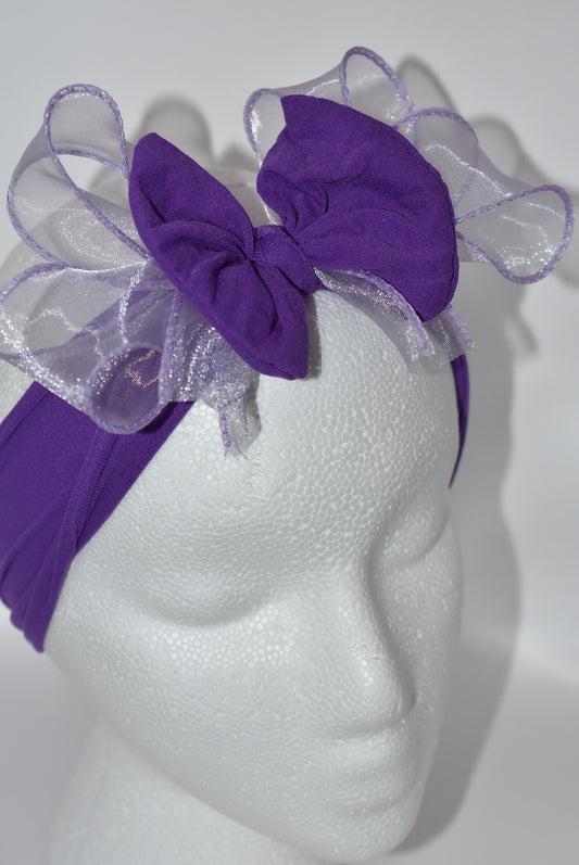 Add a vibrant pop of purple with this wide, soft headband from the Wrapped Headband Collection! 🌸 Featuring a delicate organza bow right in the center, it brings extra charm and love 💜 Perfect for all ages, it's the playful accessory you need to brighten any outfit! ✨