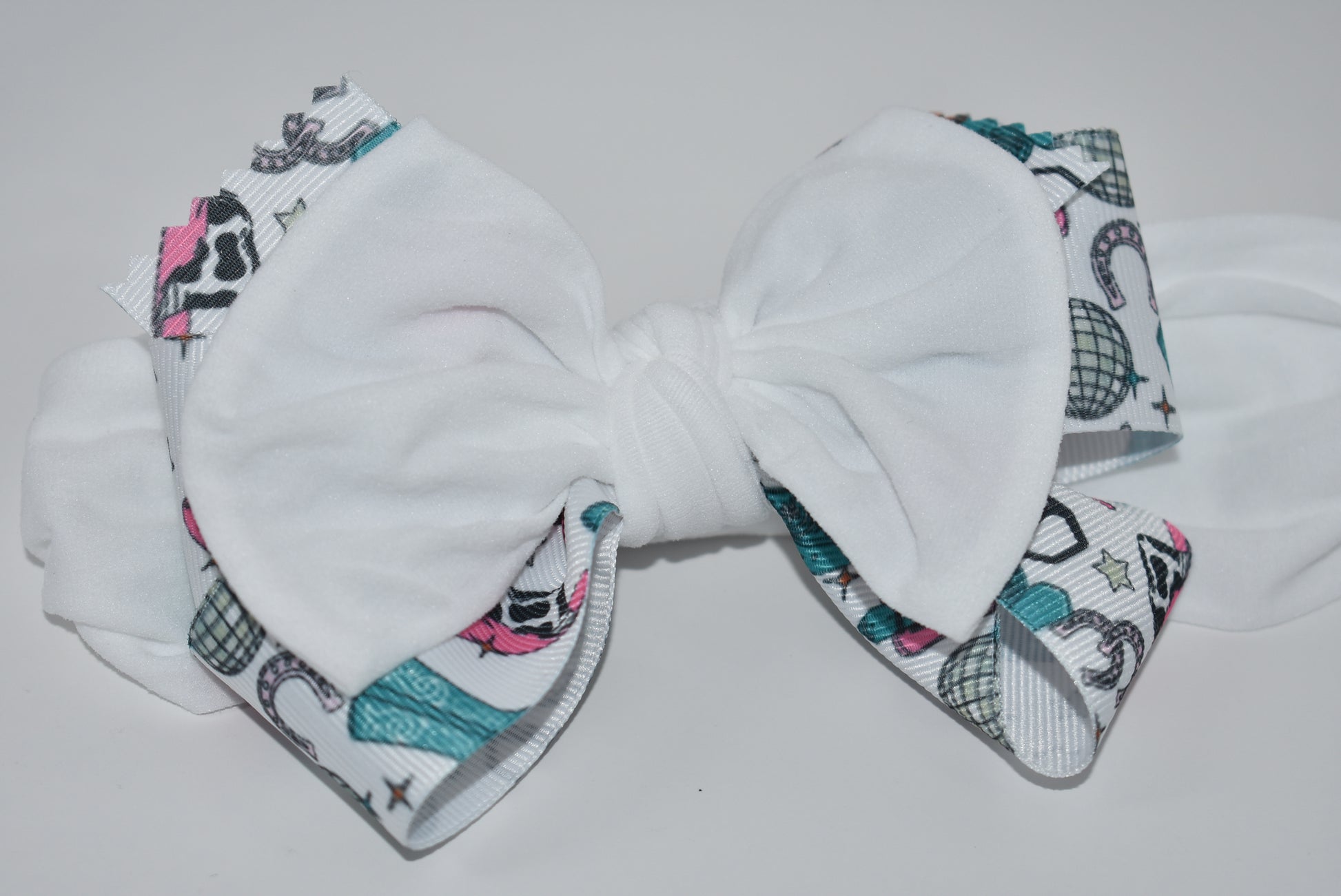 Get ready to ride in style with this pretty white wide headband! Featuring a soft fabric and a charming cowgirl bow in the center, it’s comfortable and perfect for cowgirls of all ages. Add a fun and unique touch to any outfit—giddy up! 🤠🎀💖