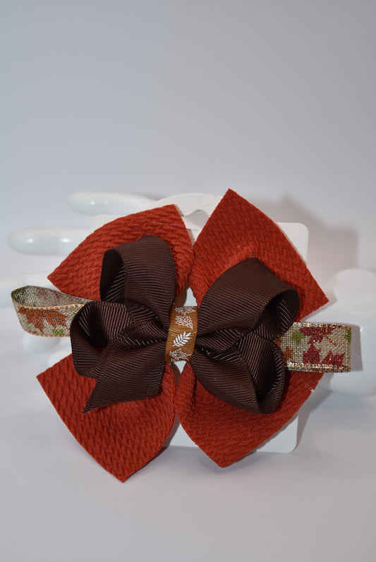 Step into fall fashion with Nana's Collection! This perfect bow features layers of pretty brown tones, accented with a leaf motif for a one-of-a-kind piece. With an alligator clip for a secure fit, this bow is both stylish and practical.