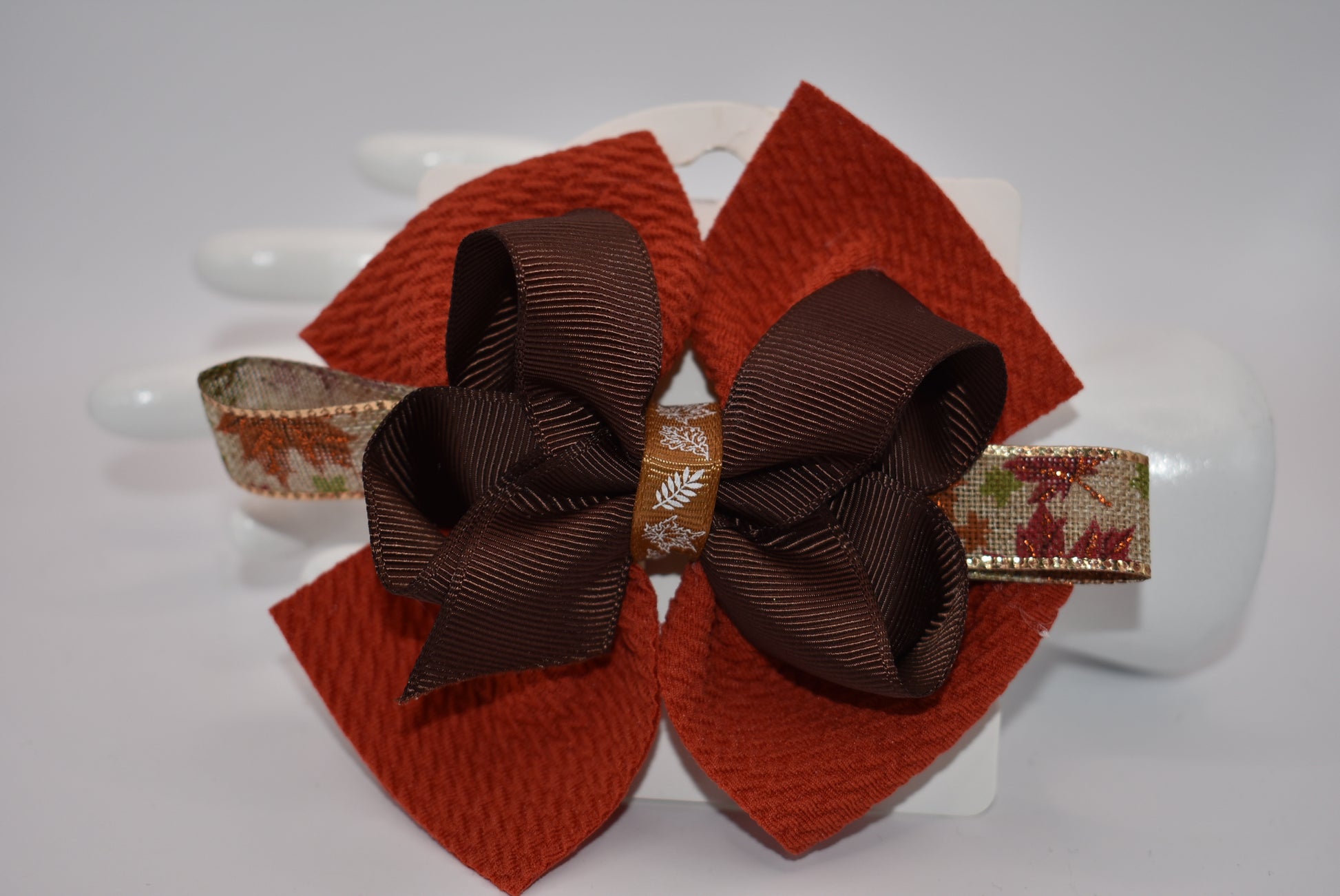 Step into fall fashion with Nana's Collection! This perfect bow features layers of pretty brown tones, accented with a leaf motif for a one-of-a-kind piece. With an alligator clip for a secure fit, this bow is both stylish and practical.