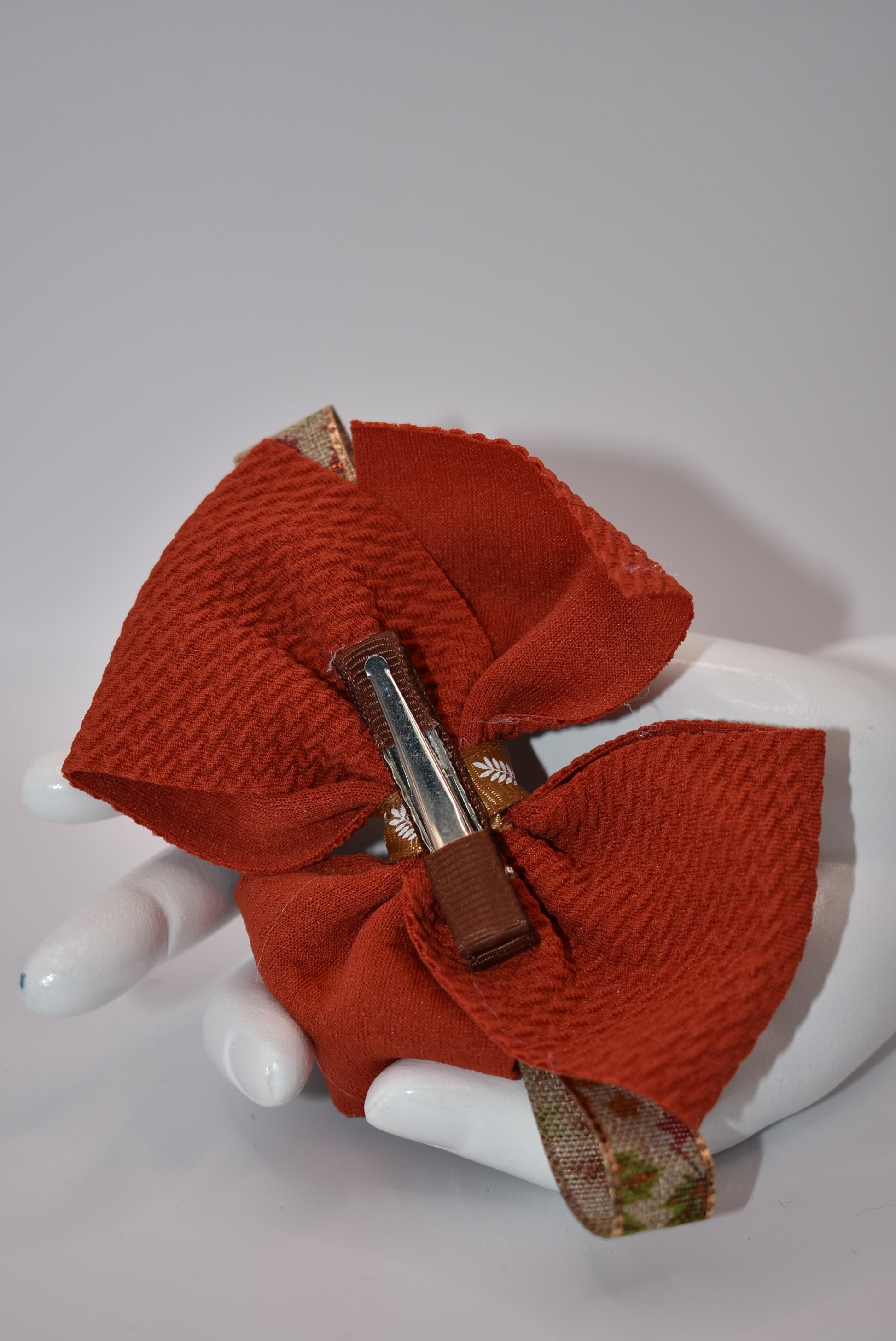 Step into fall fashion with Nana's Collection! This perfect bow features layers of pretty brown tones, accented with a leaf motif for a one-of-a-kind piece. With an alligator clip for a secure fit, this bow is both stylish and practical.