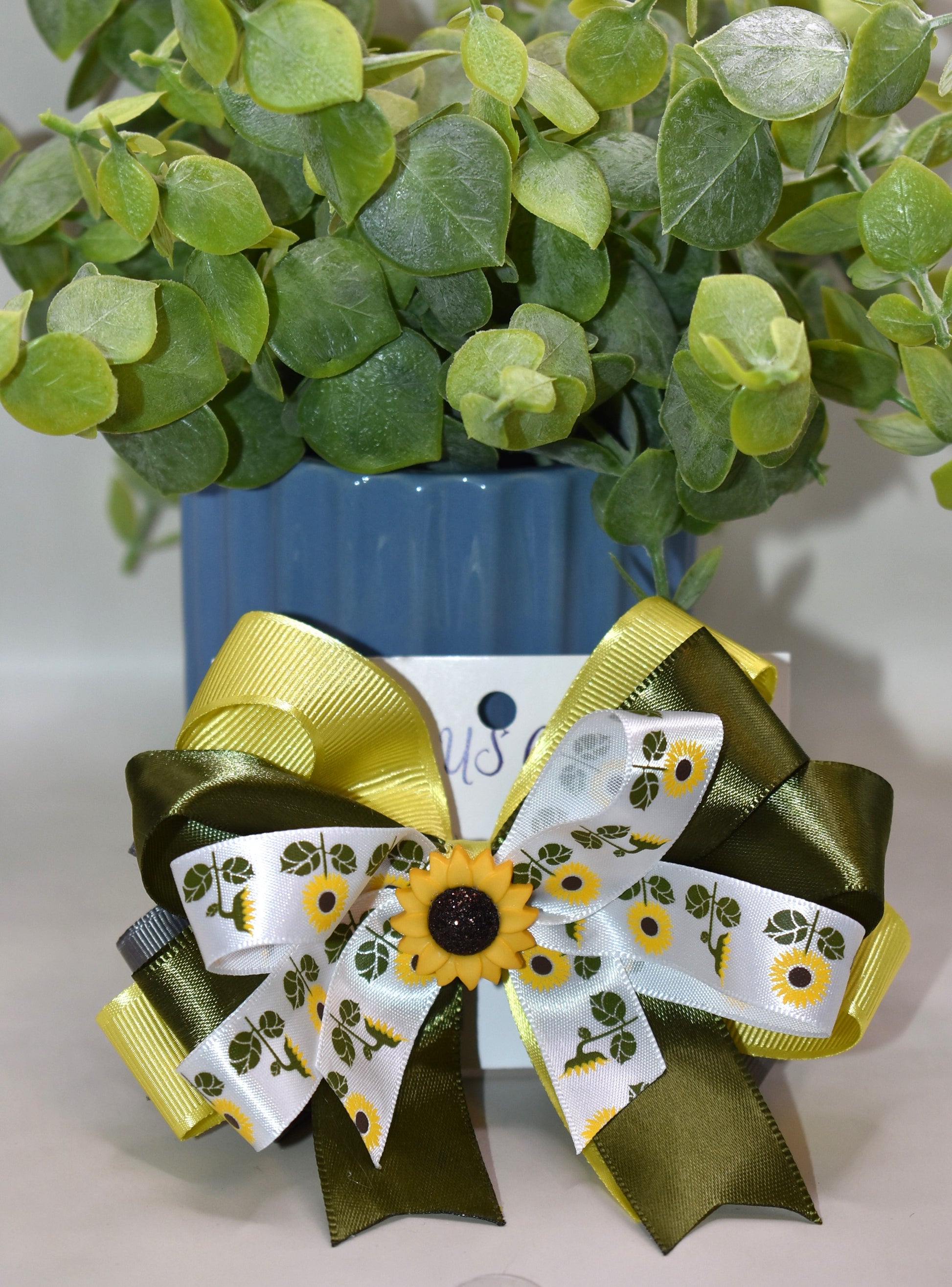 Brighten any day with this pretty olive green ribbon hair clip adorned with a super cute sunflower charm 🌻. Featuring layers and layers of lovely ribbon, it wraps comfortably around a secure alligator clip. Perfect for the little sunflower lover who wants to shine with playful style! 🌞