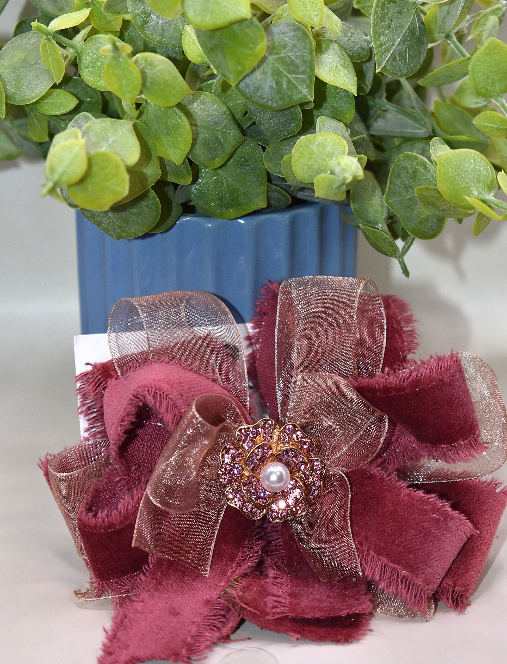 Add a playful pop of color with this gorgeous burgundy velour ribbon accented by soft pink organza. Perfect for dressing up a special outfit for you or your little one, it features a wrapped alligator clip for secure, all-day wear. A sparkling pink rhinestone and pearl piece crowns the top, tying the whole look together with charming sparkle.