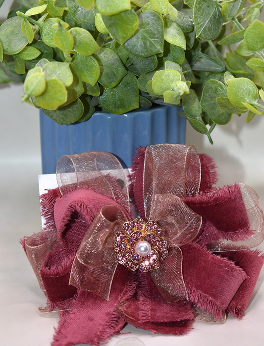Add a playful pop of color with this gorgeous burgundy velour ribbon accented by soft pink organza. Perfect for dressing up a special outfit for you or your little one, it features a wrapped alligator clip for secure, all-day wear. A sparkling pink rhinestone and pearl piece crowns the top, tying the whole look together with charming sparkle.