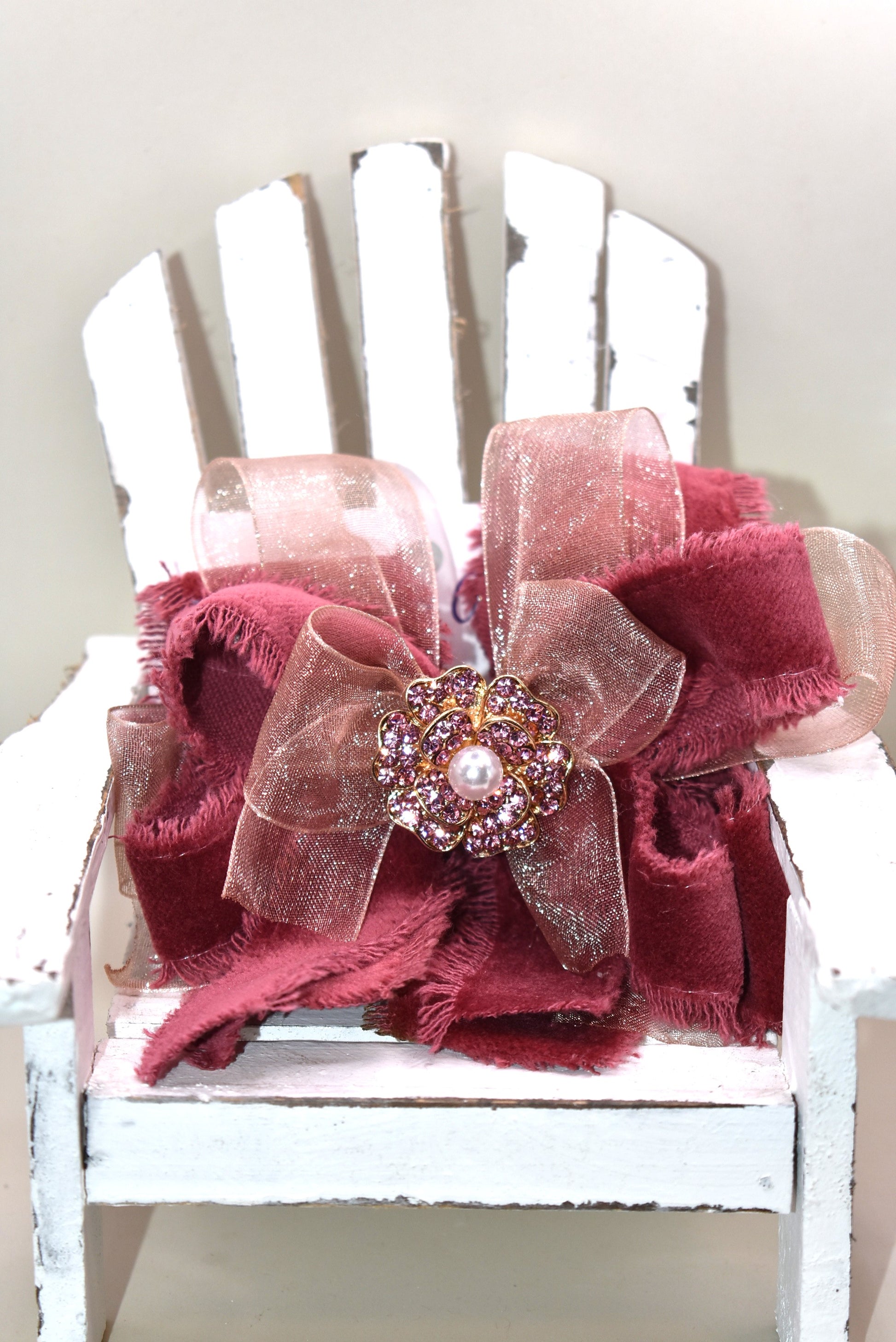 Add a playful pop of color with this gorgeous burgundy velour ribbon accented by soft pink organza. Perfect for dressing up a special outfit for you or your little one, it features a wrapped alligator clip for secure, all-day wear. A sparkling pink rhinestone and pearl piece crowns the top, tying the whole look together with charming sparkle.