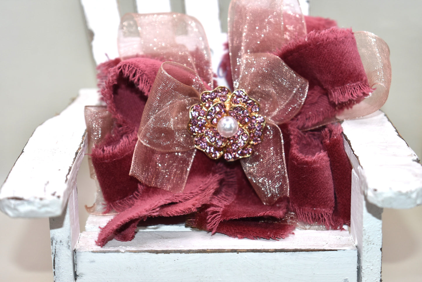 Add a playful pop of color with this gorgeous burgundy velour ribbon accented by soft pink organza. Perfect for dressing up a special outfit for you or your little one, it features a wrapped alligator clip for secure, all-day wear. A sparkling pink rhinestone and pearl piece crowns the top, tying the whole look together with charming sparkle.