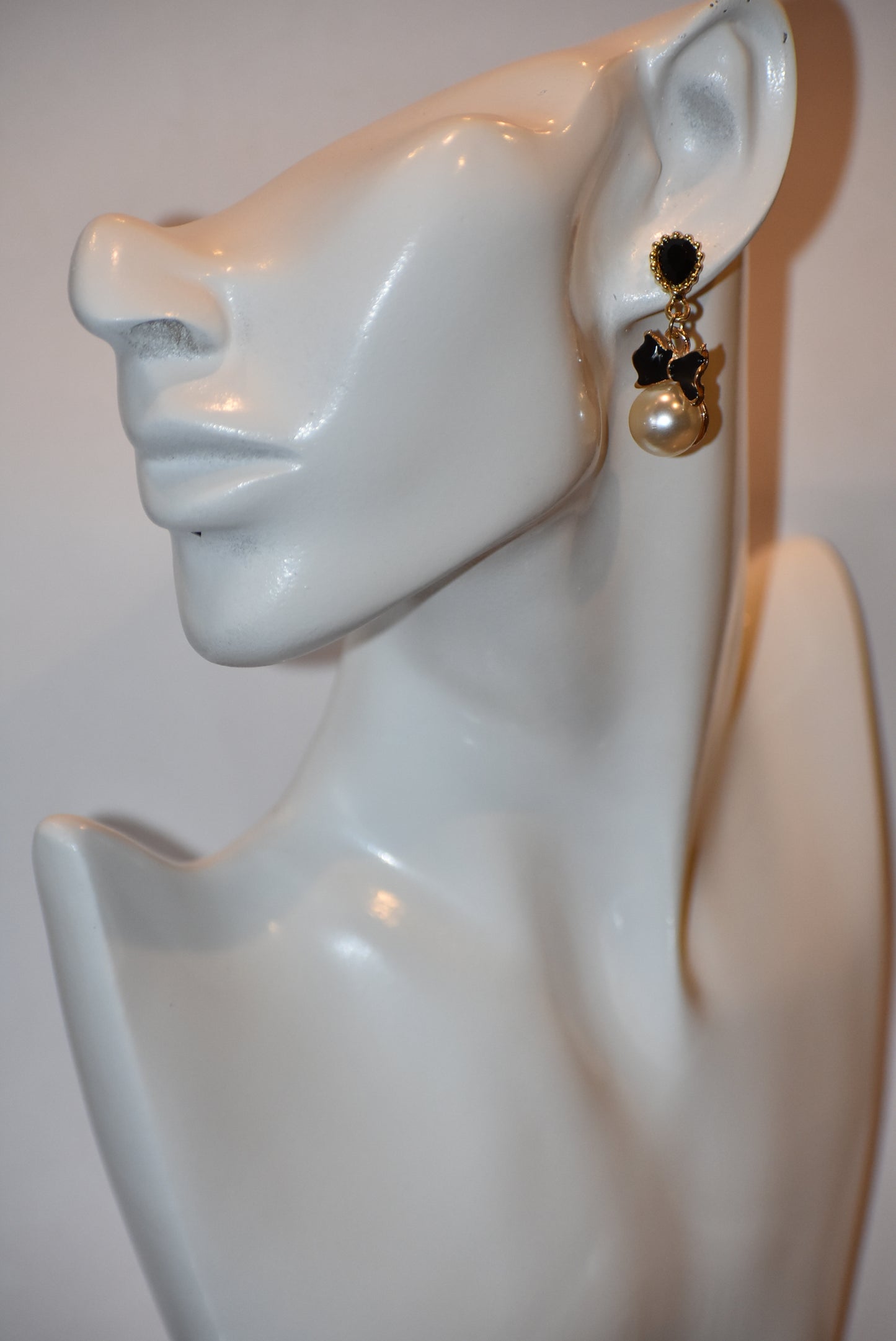 Introducing our Wedding Collection, the perfect choice for those looking for unique and stylish earrings. Our black and gold pear shaped posts feature a stunning large pearl and black tie charm, adding a touch of elegance to any outfit. Crafted with comfort and hypoallergenic materials, these earrings are perfect for sensitive ears.