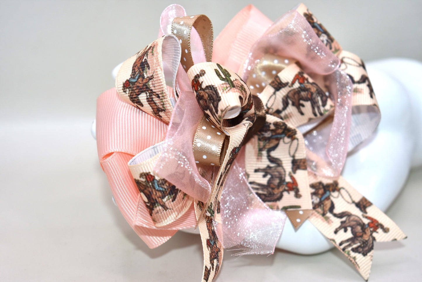 🐴 Calling all little cowgirls! This adorable smaller version of her sister bow brings the perfect mix of ribbon charm with a fun horse riding motif. With a wrapped alligator clip on the back, it’s easy to wear and stay put during all your adventures. You’re sure to fall in love with this cutie—ready to add a bit of playful flair to any outfit! 🎀✨