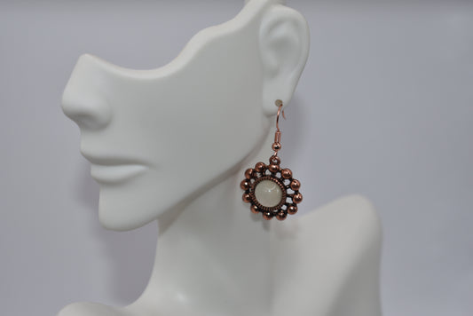 Step out in style with our Orange Collection copper hanging earrings! These pretty earrings feature hypoallergenic hook posts, ensuring comfort for sensitive ears. The opal center of the charm adds a touch of elegance and the playful design is sure to turn heads. Perfect for any fun occasion, these earrings will make a statement without taking themselves too seriously.